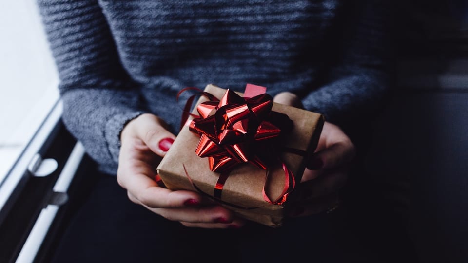 person-holding-wrapped-gift-box